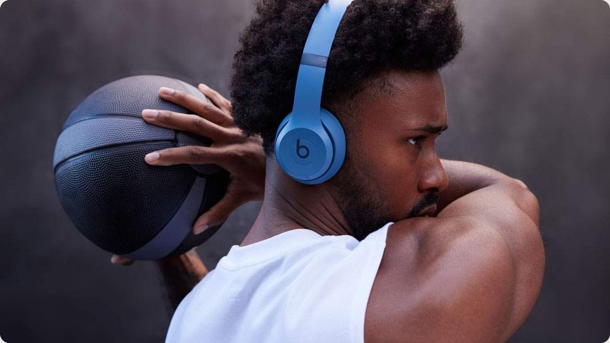 Un hombre con un balón de baloncesto en la mano mientras lleva los auriculares Solo 4
