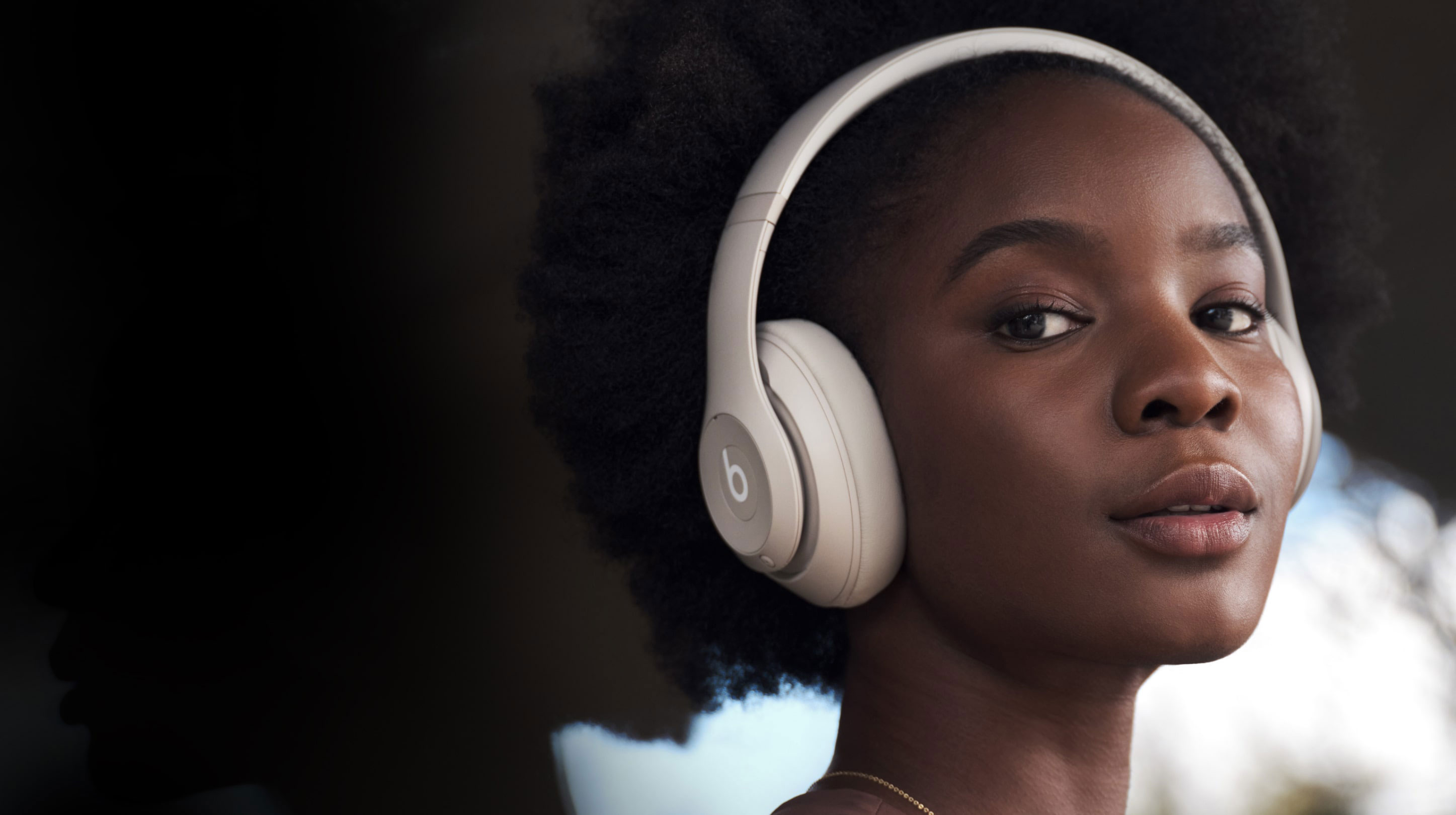 Person wearing Beats Studio Pro Wireless Headphones in the color Sandstone